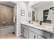 This bright bathroom features double sinks with matte black faucets and a tiled shower and tub combo at 2087 Generations Aly, Brighton, CO 80601