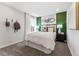 This bedroom has a plush bed, designer lighting, and a calming green accent wall at 2087 Generations Aly, Brighton, CO 80601