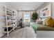 A charming bedroom with a daybed complemented by a decorative bookcase, plant and natural light from the window at 2087 Generations Aly, Brighton, CO 80601