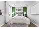 This bedroom has a plush bed, designer lighting, and a calming green accent wall with modern art at 2087 Generations Aly, Brighton, CO 80601