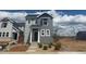 Charming two-story home with gray siding and white trim, complemented by fresh landscaping at 2087 Generations Aly, Brighton, CO 80601