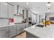 Stylish kitchen featuring gray cabinets, stainless steel appliances, and a white countertop island with sink at 2087 Generations Aly, Brighton, CO 80601