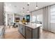 Modern kitchen features an island, stainless steel appliances, and an open floor plan to the living area at 2087 Generations Aly, Brighton, CO 80601