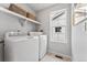 This laundry room features a side-by-side washer and dryer beneath a floating shelf at 2087 Generations Aly, Brighton, CO 80601