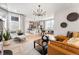 Open-concept living space with modern furnishings, hardwood floors, a stylish light fixture, and kitchen views at 2087 Generations Aly, Brighton, CO 80601