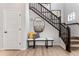 Close up of an elegant staircase with dark wood railing, carpeted steps, and stylish wall decor at 2087 Generations Aly, Brighton, CO 80601