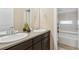 Bathroom featuring double sinks, a dark vanity, and a shower/tub combo with tiled walls at 3269 Uinta St, Denver, CO 80238