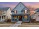 Charming two-story home featuring a welcoming front porch and red shutters against a blue exterior at dusk at 3269 Uinta St, Denver, CO 80238