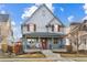 Charming two-story home featuring a welcoming front porch and red shutters against a blue exterior on a sunny day at 3269 Uinta St, Denver, CO 80238