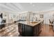 Open kitchen island with seating overlooks the living and dining areas with fireplace at 3269 Uinta St, Denver, CO 80238