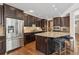 Spacious kitchen with dark wood cabinets, granite island, stainless steel appliances and seating at 3269 Uinta St, Denver, CO 80238