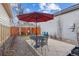 Outdoor patio area with table and chairs under a red umbrella, surrounded by a wooden fence at 3269 Uinta St, Denver, CO 80238