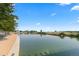 Peaceful community pond with benches and lush greenery along the edge on a clear day at 3269 Uinta St, Denver, CO 80238