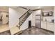 Basement bar with sleek gray floors, stainless steel beverage cooler, granite countertops, and adjacent staircase at 9724 Crowsley Ct, Parker, CO 80134