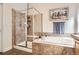 Bright bathroom with a shower, soaking tub, and neutral tile at 9724 Crowsley Ct, Parker, CO 80134