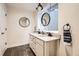 Well-lit bathroom features a double vanity, granite countertops, and stylish hanging mirrors at 9724 Crowsley Ct, Parker, CO 80134