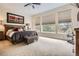 Spacious bedroom featuring neutral carpet, large windows, and a decorative trunk at the foot of the bed at 9724 Crowsley Ct, Parker, CO 80134