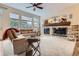 Living room featuring a fireplace with stone accents and large windows for natural light at 9724 Crowsley Ct, Parker, CO 80134