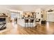 Open-concept living space with granite kitchen island, wood floors, and dining space at 9724 Crowsley Ct, Parker, CO 80134