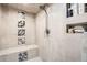 Modern shower features tiled walls, a built-in bench, and convenient storage niche at 9724 Crowsley Ct, Parker, CO 80134