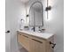 Modern bathroom with floating vanity, black matte fixtures and arched mirror at 5550 E Thrill Pl, Denver, CO 80207