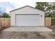 Detached single car garage with white paneling and new driveway at 5550 E Thrill Pl, Denver, CO 80207