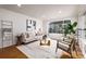 Bright and airy living room with hardwood floors and modern furniture at 5550 E Thrill Pl, Denver, CO 80207