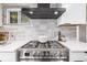 Stainless steel gas stove with modern range hood at 5550 E Thrill Pl, Denver, CO 80207