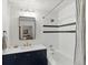 Clean bathroom featuring a white shower/tub, dark vanity with a mirror, and modern fixtures, complemented by white walls at 1499 Blake St # 3U, Denver, CO 80202