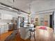 Spacious kitchen and dining area with stainless steel appliances, modern island, hardwood floors, and exposed ductwork at 1499 Blake St # 3U, Denver, CO 80202