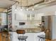 Contemporary kitchen features white cabinetry, stainless steel appliances, a central island with bar stools, and modern lighting at 1499 Blake St # 3U, Denver, CO 80202
