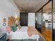 Modern main bedroom featuring an eclectic mix of decor and furniture, with a glass partition and exposed concrete ceiling at 1499 Blake St # 3U, Denver, CO 80202