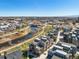 Aerial view of urban neighborhood with a winding river, pedestrian paths and modern townhomes at 5004 S Platte River Pkwy, Littleton, CO 80123
