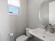 Elegant powder room with pedestal sink, modern fixtures, and natural light at 5004 S Platte River Pkwy, Littleton, CO 80123