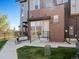 Brick townhouse front entrance with a small porch and a 'For Sale' sign in the yard at 5004 S Platte River Pkwy, Littleton, CO 80123