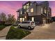 Modern townhouse with striking architectural design featuring a car parked in the driveway under a colorful sunset sky at 5004 S Platte River Pkwy, Littleton, CO 80123