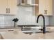 Close up on stainless cook top and backsplash in modern kitchen with gray counter tops at 5004 S Platte River Pkwy, Littleton, CO 80123