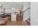 Open-concept kitchen with stainless steel appliances, a central island, and hardwood floors flowing into the living area at 5004 S Platte River Pkwy, Littleton, CO 80123