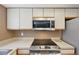 Modern kitchen with stainless steel microwave and stove top adding a sleek touch at 12655 E Pacific Cir # C, Aurora, CO 80014