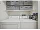 Functional laundry room with washer, dryer, storage shelves, and cleaning supplies at 12655 E Pacific Cir # C, Aurora, CO 80014