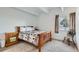 Bedroom with wooden bed frame, patterned bedding, and a window with curtains at 384 S Ironton St # 208, Aurora, CO 80012