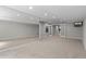 Open basement featuring a wall mirror, neutral carpet, and ample natural light at 7119 S Riviera St, Aurora, CO 80016