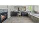 Spacious bathroom with fireplace, dual sinks, and soaking tub under a large window with backyard view at 7119 S Riviera St, Aurora, CO 80016