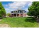 Beautiful two-story home showcasing a brick and siding exterior, lush lawn, and covered patio at 7119 S Riviera St, Aurora, CO 80016