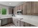 Well-equipped kitchen with stainless steel appliances, wood cabinets and sleek countertops by a large window at 7119 S Riviera St, Aurora, CO 80016