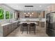 Spacious kitchen features a center island with seating and stainless steel appliances. Lots of natural light at 7119 S Riviera St, Aurora, CO 80016