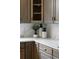 Close-up shot of kitchen features white countertops, wood cabinets, and black and white ceramic decor at 7119 S Riviera St, Aurora, CO 80016