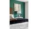 Close up of a main bedroom with a dark green accent wall and stylish decor at 7119 S Riviera St, Aurora, CO 80016