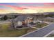Beautiful aerial view of a spacious stucco home with a manicured lawn and mountain backdrop at 16394 W 77Th Ln, Arvada, CO 80007