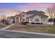 Charming stucco home showcasing a meticulously manicured lawn and stone retaining wall at 16394 W 77Th Ln, Arvada, CO 80007